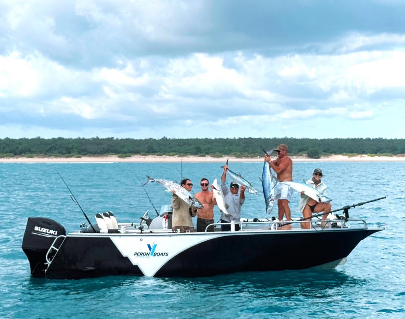 Anglers holding up their catch on the deck of an Ultra V centre console