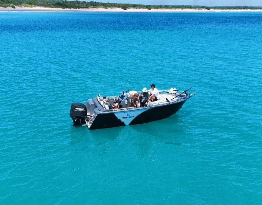 Ultra V cruising on blue water with a distant shoreline